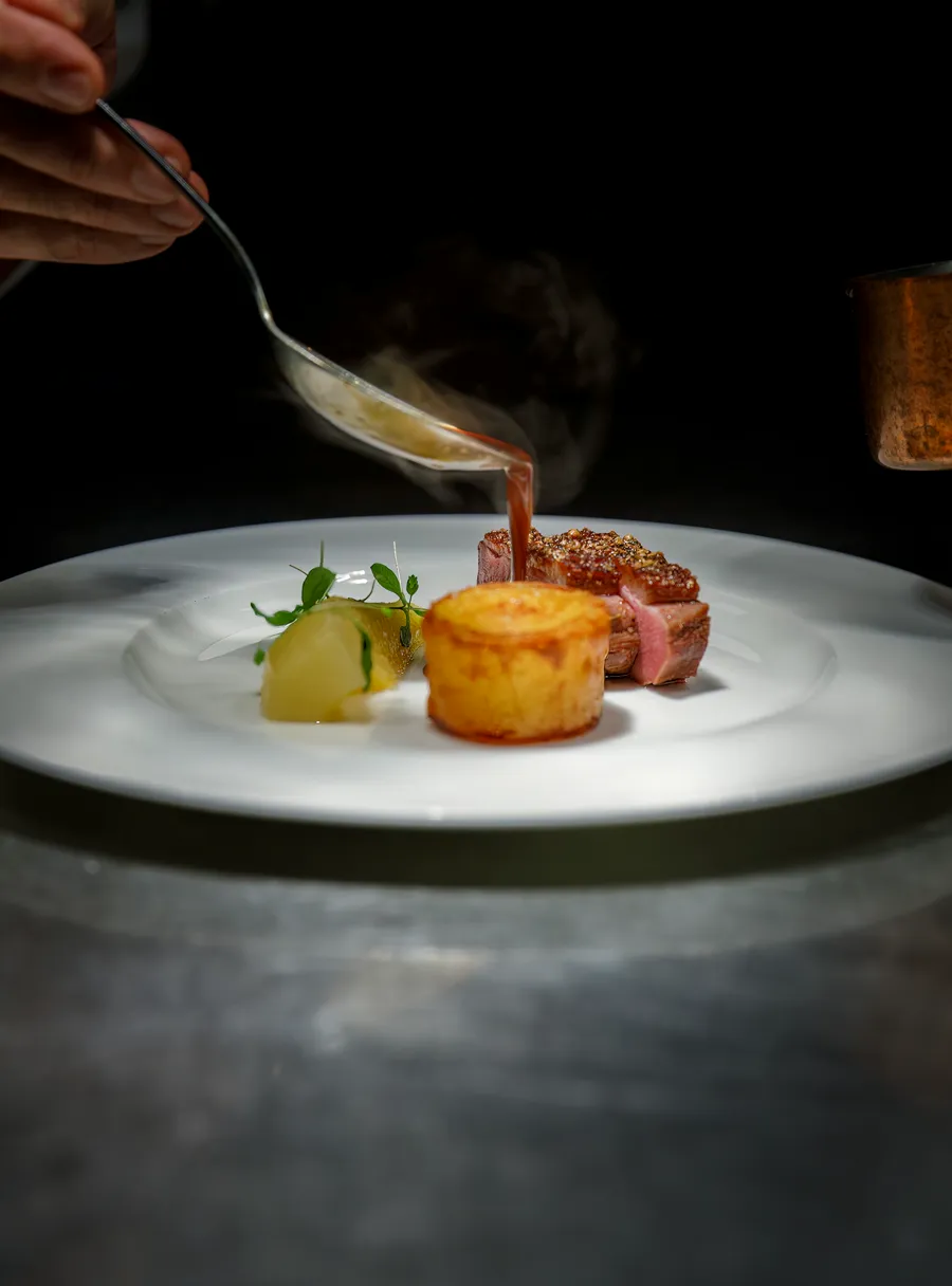 Chef finishing a plated dish